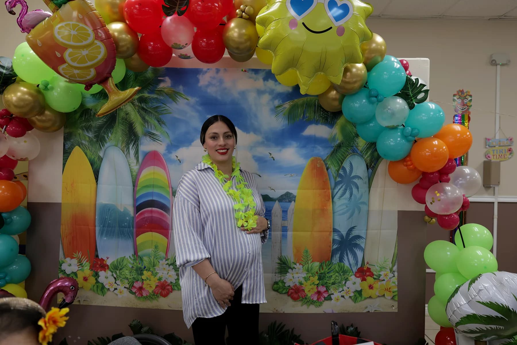 A staff member beside the decorated balloon arch