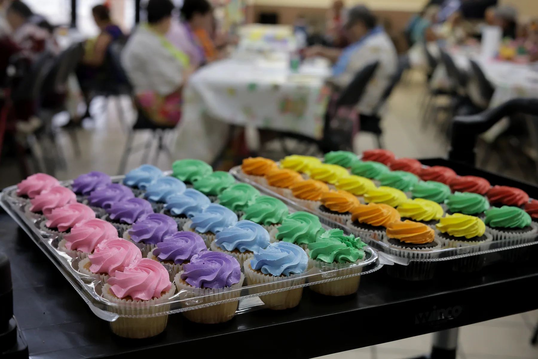 Rainbow-iced cupcakes laid out ready to serve