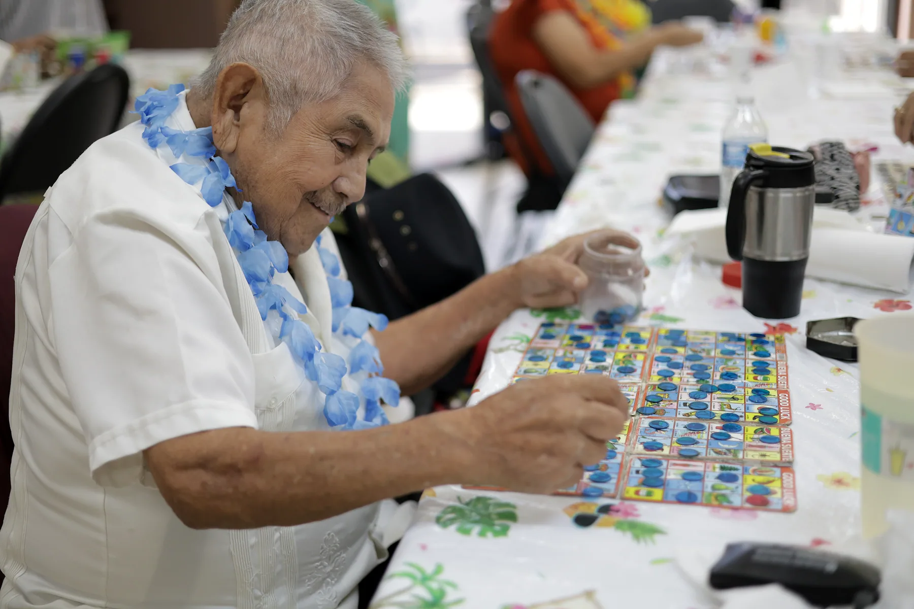 A participant smiling as he places a marker on his lotería board