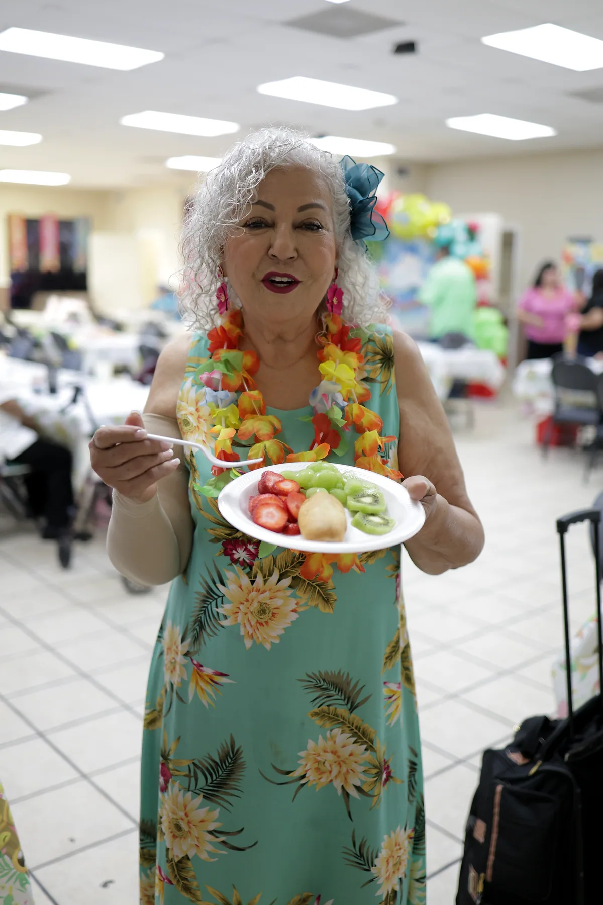 A participant with a plate of freshly cut fruit