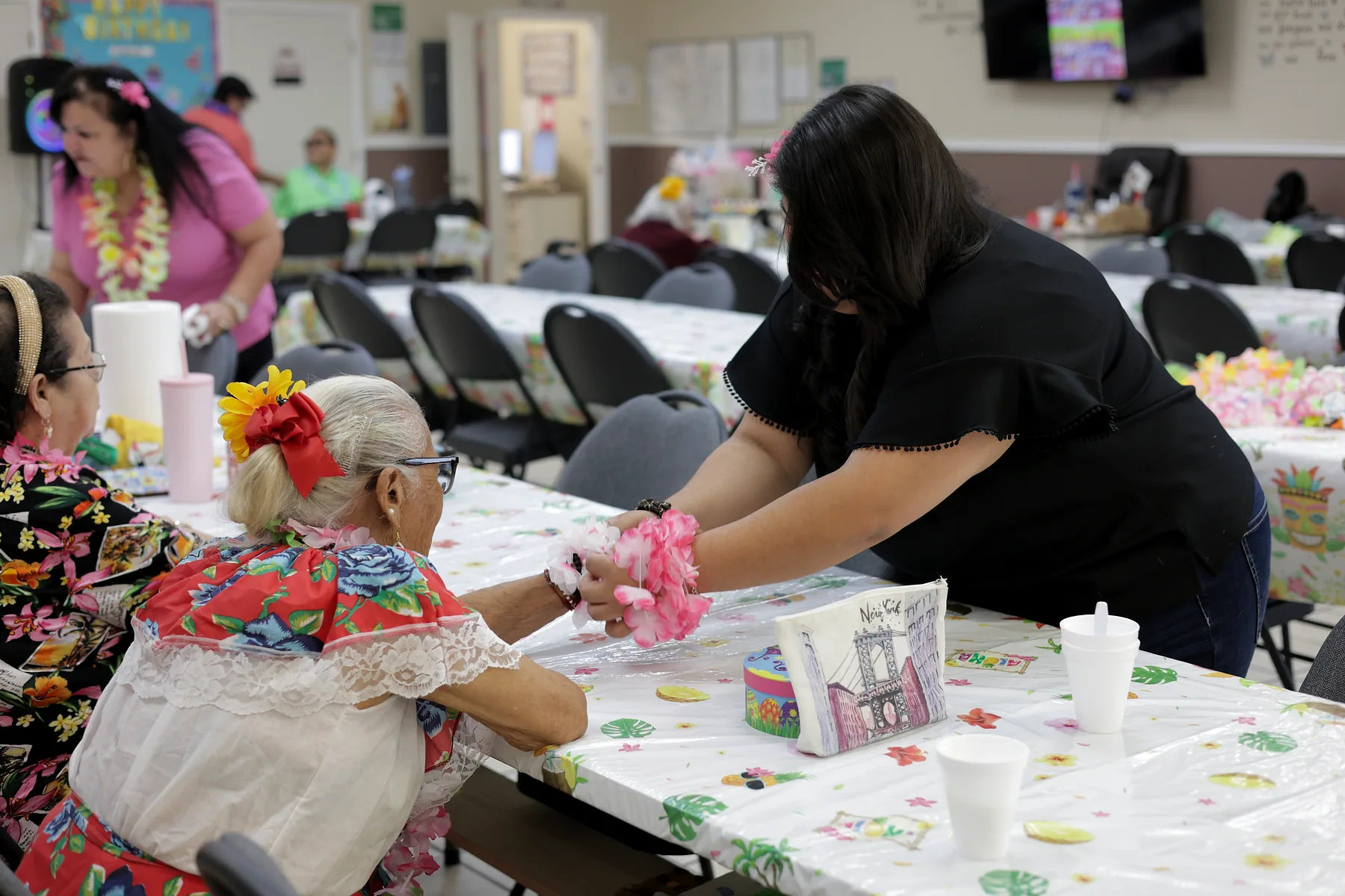 A staff member sitting with a participant to help her through the day