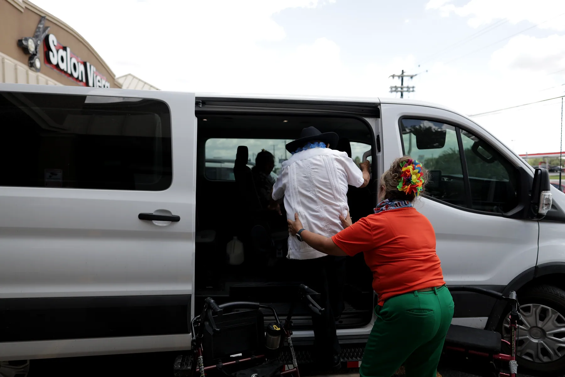 A staff member helping a participant board the center's transport van