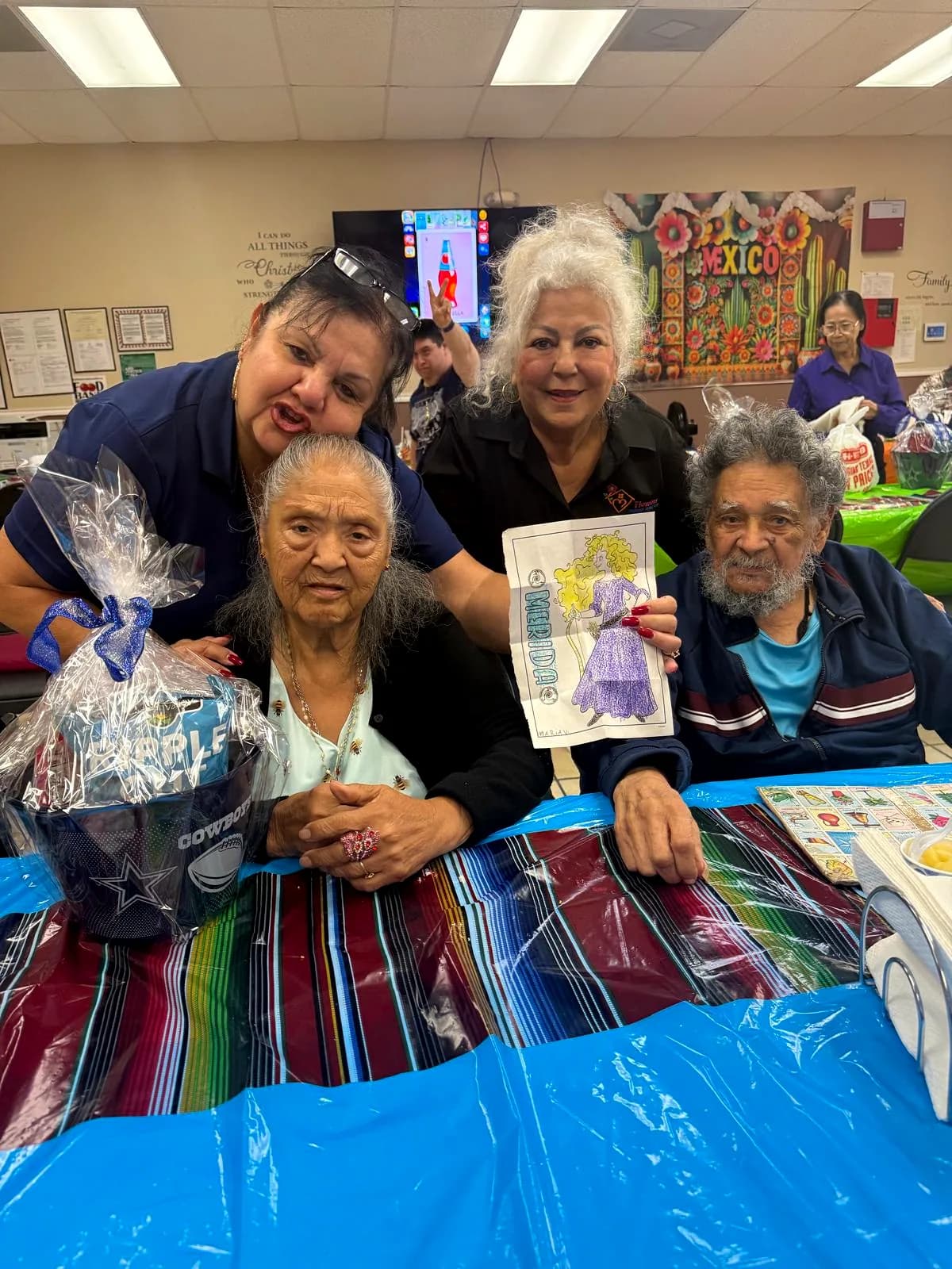 Staff and participants together with a raffle basket at the grand opening